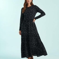 robes à pois marine manches longues mollet tachetés bleu portée par une femme sur un fond bleu avec des sandales marron