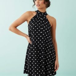 robes longues marron à pois mono nœud avec détail col montant sans manches portée par une femme
