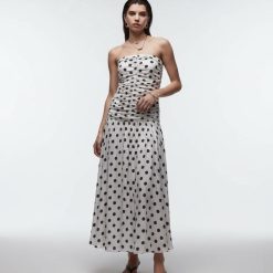 robes à pois blanc et noir froncé corsage longue taille basse bandeau portée par un mannequin sur fond blanc avec des sandales noires