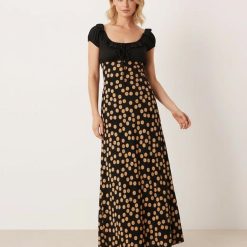 robes rouges à petit pois dégagée noué volants longue détail encolure marron femme portant une élégante robe longue noire à pois dorés et un corsage froncé