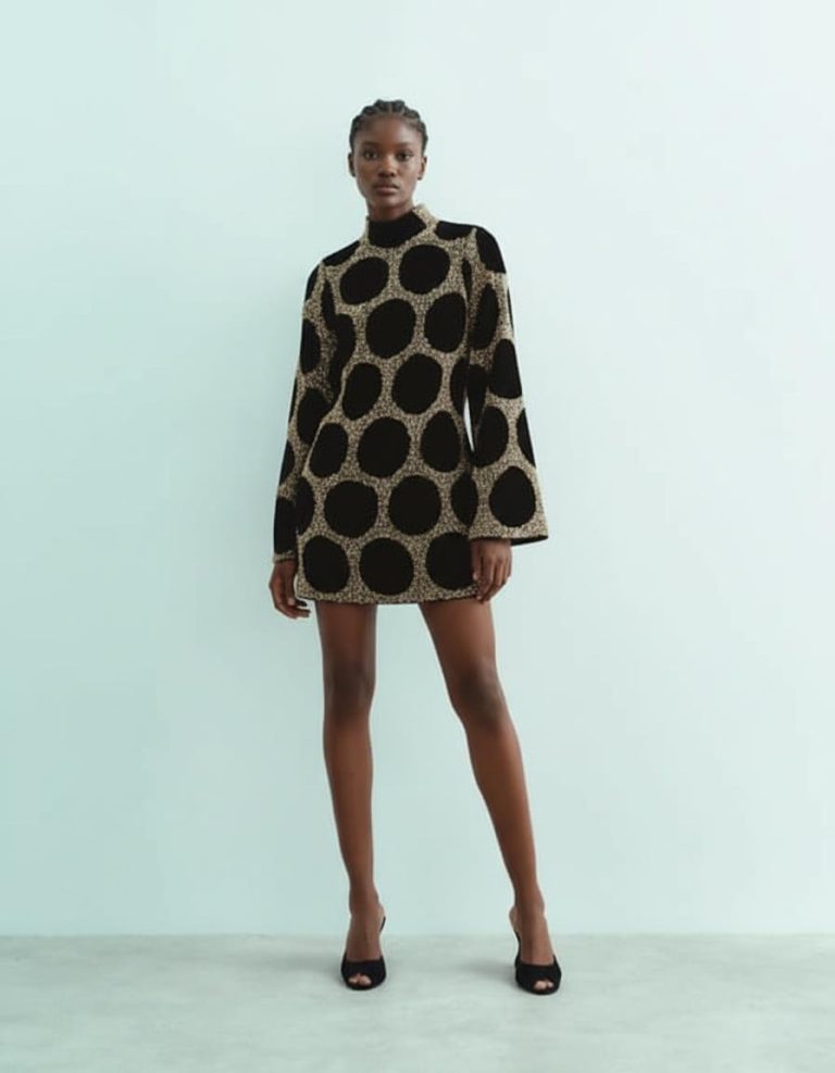 robes manches longues à pois courte ornementés noir doré portée par un mannequin avec col montant et motifs ronds dorés et noirs