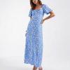 robes manches longues à pois viscose torsadé décolleté cœur bouffantes mollet bleu fleuri robe longue bleue a motifs fleurs blanches portée par un mannequin avec des tongs blanches sur un fond neutre