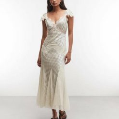 robes à pois vintages blancs dentelle longue empiècements dress tea style couleur ecru a col en v et bordure en dentelle portee par une femme avec des sandales noires