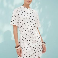 robes portefeuille à pois courte et monochrome design portée par une femme avec des manches courtes et un détail noué à la taille