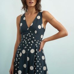 robes à pois marine bordeaux manches longues motif tacheté mollet portée par une femme souriante avec des baskets blanches coupe évasée froncée à la taille