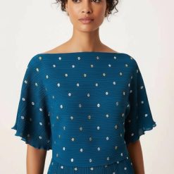 robes asymétriques à pois bleu sarcelle dénudées plissée longue métallisé épaules portée par un mannequin avec un col bateau et de petites fleurs dorées