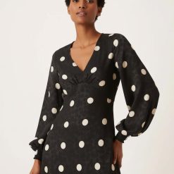 robes à pois transparentes jacquard maxi col v noirs portée par un mannequin avec manches longues bouffantes