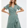 robes vertes à pois volants portefeuille courte vert une femme porte une robe verte à pois noirs avec des volants et un col en v une robe dété parfaite pour les jours ensoleillés