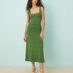 robes vertes à pois adrian bretelles nouées mi longue ajustee avec encolure carree portee par un mannequin