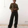 cardigans à pois et imprimé carrée coupe brown porté par une femme aux cheveux bouclés avec des pois vert pomme