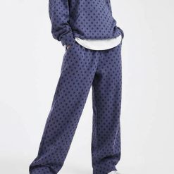 joggings à pois bleu ample pantalon de jogging porté par une femme avec un sweat à capuche assorti et des baskets sur fond bleu