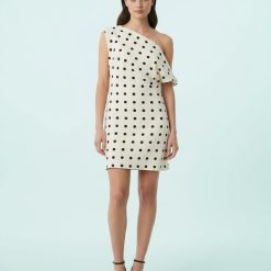 robes asymétriques à pois drapée courte en satin babeurre portée par un mannequin femme avec des sandales noires