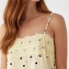 nuisettes à pois longue dentelle robe fines bretelles avec bordures imprimé jaune pastel portée par un mannequin sur fond bleu