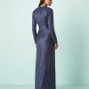 robes à pois bleu marine buste satinée longue biais fantaisie vue de dos portée par un mannequin élégant sur fond bleu avec des talons noirs