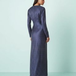 robes à pois bleu marine buste satinée longue biais fantaisie vue de dos portée par un mannequin élégant sur fond bleu avec des talons noirs