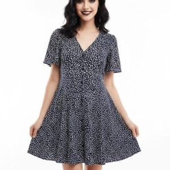 robes à pois vertes boutonnée courte et patineuse imprimé col en v manches courtes portée par une femme sur fond blanc