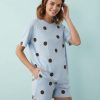 pyjamas à pois bleu chocolat ensemble short t-shirt oversize maternity porté par une femme souriante sur un fond bleu clair
