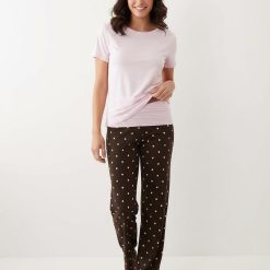 pyjamas à pois marron ensemble pantalon rabat avec t-shirt doux fluide rose clair porté par une femme sur fond blanc