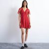 robes à pois rouge cape godets courte et manches ourlet fluides portee par une femme souriante avec mocassins noirs et chaussettes blanches