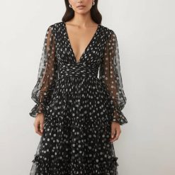 robes à pois transparentes tulle longue décolleté plongeant volants manches ballon noir et blanc portée par un mannequin sur fond neutre