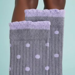 chaussettes à pois design style gris et lilas hautes en tricot côtelé gris avec des motifs violet clair portées sur les jambes