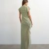 robes mousseline à pois verts longue asymétrique smocké détail ourlet vue de dos portée par un mannequin avec des volants sur le côté et des manches courtes