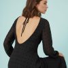 robes à pois années 50 noir floqués en mousseline longue manches ange portée par une femme avec des talons noirs