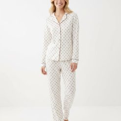 pyjamas à pois écru ensemble doux ultra boutonné porté par une femme comprenant un haut à manches longues et un pantalon assorti