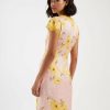 robes à pois jaune et rose longue imprimé coquelicots col v portée par un mannequin de profil avec des manches courtes en dentelle jaune