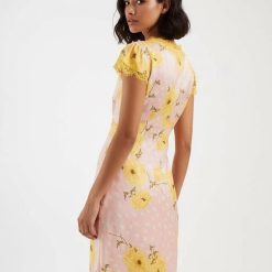 robes à pois jaune et rose longue imprimé coquelicots col v portée par un mannequin de profil avec des manches courtes en dentelle jaune