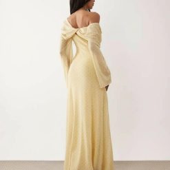 robes à pois jaune drapée longue épaules dénudées manches lemon vue de dos portée par une femme avec des talons noirs