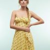 robes à pois jaune amovible détail foulard structurée taille longue style art déco portée par un mannequin avec coupe asymétrique et imprimé cercle