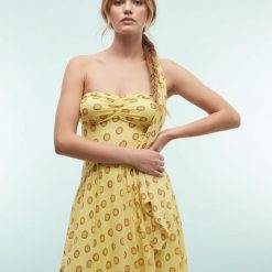 robes à pois jaune amovible détail foulard structurée taille longue style art déco portée par un mannequin avec coupe asymétrique et imprimé cercle
