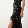robes longues rouges à pois blancs caraco noir portee par un mannequin avec volant et fente sur la jambe
