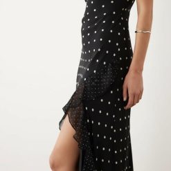 robes longues rouges à pois blancs caraco noir portee par un mannequin avec volant et fente sur la jambe