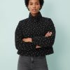 vestes à pois noir denim style cheminée col sport portée par une femme avec un jean gris