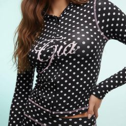 sweats à pois capuche pantalon contrastantes fermeture éclair ensemble noir un ensemble confortable et tendance avec des pois blancs sur fond noir et un détail rose sur la fermeture éclair