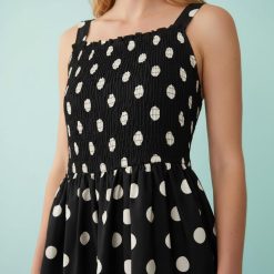 robes vintages rouges à pois basse taille courte froncée avec noir femme élégante sans manches pois blancs fond noir ourlet volanté style décontracté