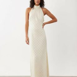 robes à pois transparentes mousseline longue col montant dos nu couleur crème portée par un mannequin femme avec un motif jacquard discret