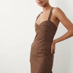 robes évasées à pois ourlet nu avec dos marron portée par un mannequin avec un col coeur et bretelles