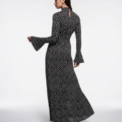 robes évasées à pois longue en satin manches nœud minuit une femme porte élégamment cette longue robe à pois noirs et blancs avec des manches évasées