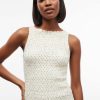 robes asymétriques à pois courte taille basse crème débardeur sans manches ajusté avec un motif à petits pois trouvé sur un mannequin femme noire aux cheveux courts coupe au carré devant un fond blanc