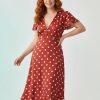 robes à pois rouge évasés col v et mancherons portée par une femme aux cheveux roux
