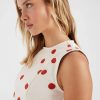 robes à pois rouge courte robe design rouges sans manches couleur ecru portee par une jeune femme vue de profil