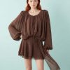 robes longues marron à pois manches ballon mousseline drapés chocolat courte portée par un mannequin rousse sur fond bleu