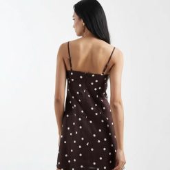 robes longues marron à pois froncé lin buste chêne foncé une élégante robe courte à bretelles fines avec des pois blancs sur un tissu foncé vue de dos sur une femme