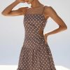 robes longues marron à pois chocolat bretelles fines lin découpe côté portée par un mannequin sur un fond bleu clair avec des sandales blanches