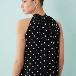 robes longues marron à pois mono nœud avec détail portée par une femme vue de dos avec un col halter élégant