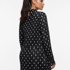 robes à pois blanc et noir manches courte plissée longues portée par une femme vue de dos avec un col montant