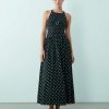 robes à pois blanc et noir bretelles croisées dos effet froissé monochrome robe longue col halter portée par une femme avec des sandales